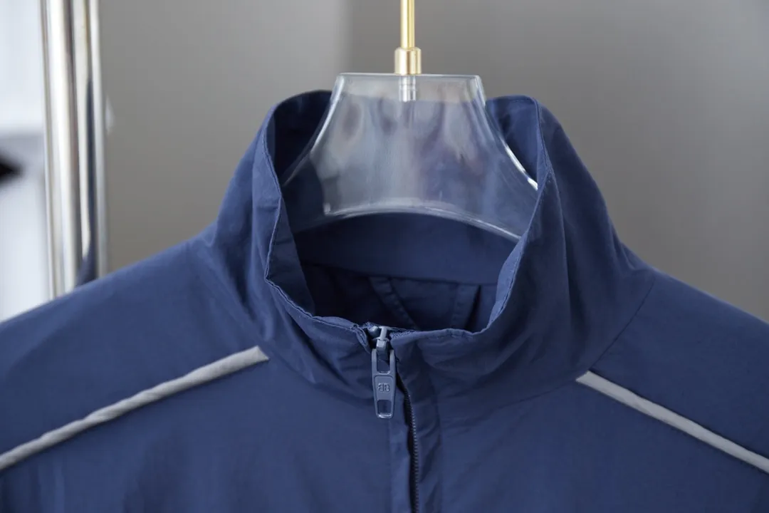 𝘽𝘼𝙇*𝙉𝘾𝙄𝘼𝙂𝘼 Navy half-ring embroidered reflective striped jacket Light luxury A must-have item for daily commuting for men and women Correct version Welcome to compare Detailed features · Customized matt Taslan jacket fabric · The fabric has undergone a waterproof coating process · The interior is made of three-level polyester bird's eye mesh · OS ultra-loose silhouette design · Side zipper pockets, small high stand-up collar design · Internal zipper pocket design · Elastic waistband design at the hem · Customized molded hardware zipper Jacket double puller design · Tajima high-speed embroidery machine with 100,000 three-dimensional needles · Embedded design of reflective strips · Customized molded original logo hardware zippers · Original main mark washed tag packaging Color: Navy Size: 46/48/50/52